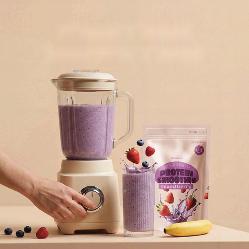 Blender with a berry smoothie next to an Allreasons smoothie pouch