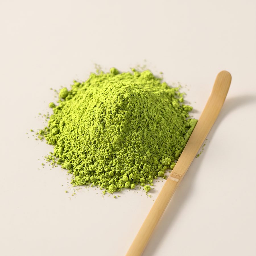 Close-up of fine green Ceremonial Matcha powder with a bamboo scoop