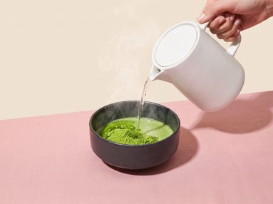 Step 2, pouring hot water onto sifted matcha in a ceramic bowl