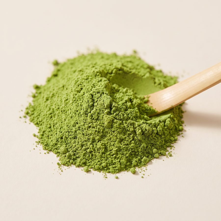Close-up of fine green Premium Matcha powder with a bamboo scoop