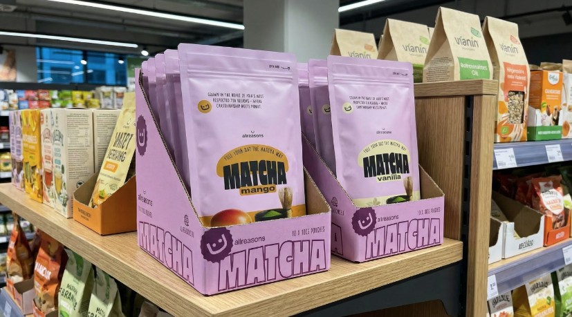 Allreasons matcha latte display cases on a retail shelf, with mango and vanilla pouches front facing